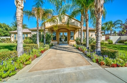 pathway surrounded by trees and grass leading up to a clubhouse